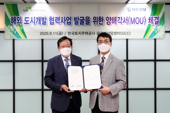 11일 경기도 성남시 분당 LH 오리사옥에서 김창환 대우건설 신사업본부장(왼쪽)과 이용삼 LH 글로벌사업본부장이 MOU 체결 후 기념사진을 촬영하고 있다./대우건설