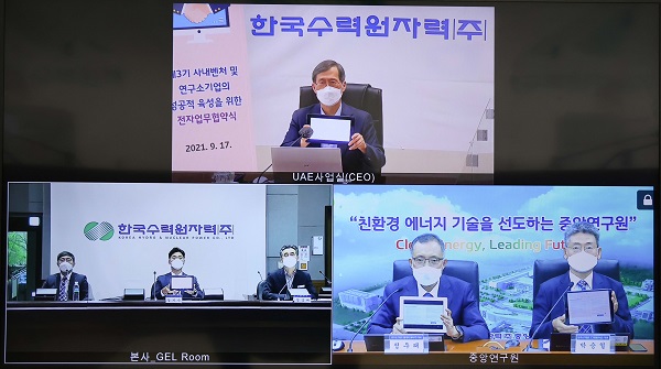 연구소기업 설립을 위한 기본합의서 서명식에서 정재훈 한수원 사장(위쪽)이 전자서명으로 서명한 뒤 사진 촬영을 하고 있다.(사진=한국수력원자력)